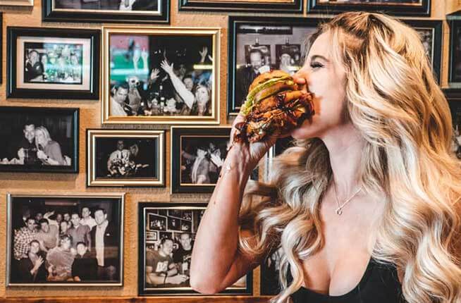 Women eating a burger Lucky Beaver Bar & Burger
