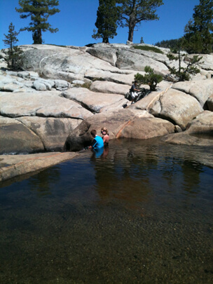 Family camping and swimming in river 