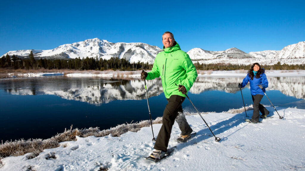 Couple snowshoeing at Kiva Beach with Mt Tallac in background