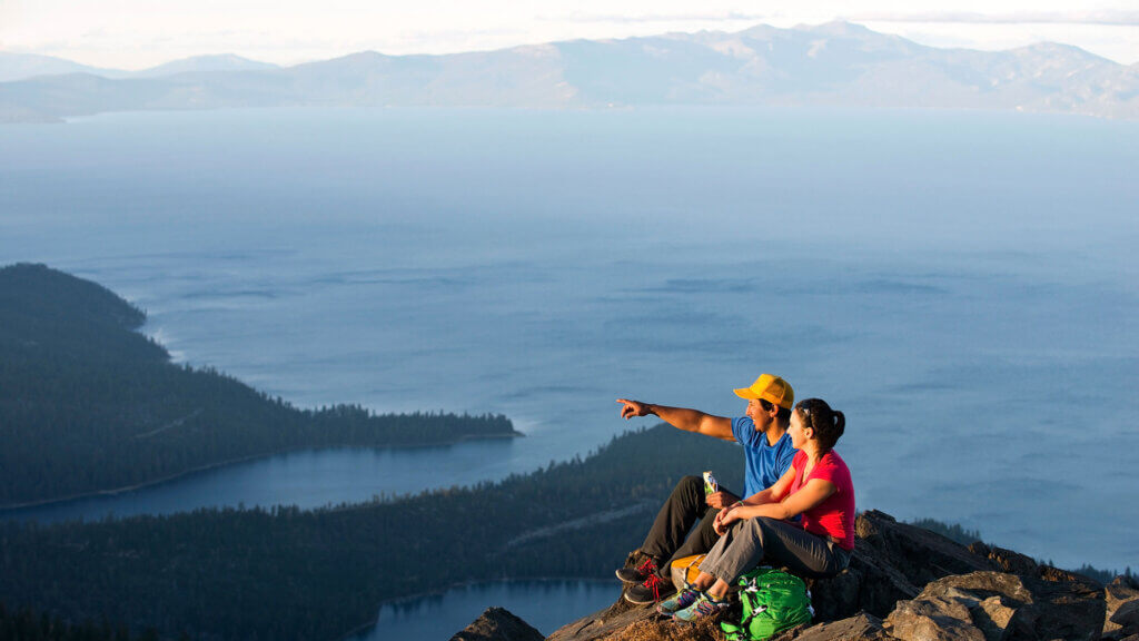 A couple looking at the view of Lake Tahoe from the top of Mt Tallac