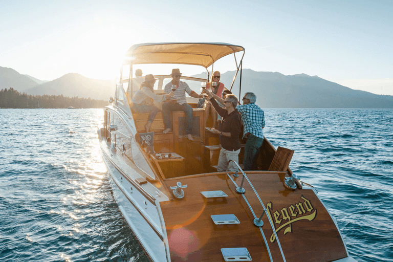 friends drink wine on a boat at sunset on Lake Tahoe