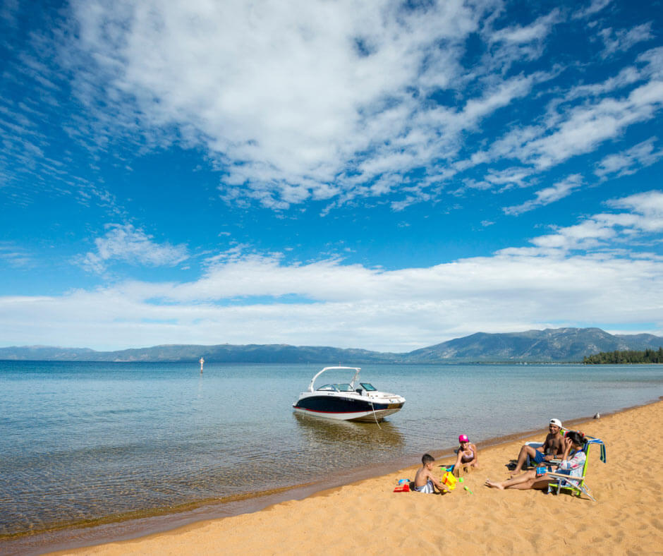 A family of four enjoy a day at the beach with their boat