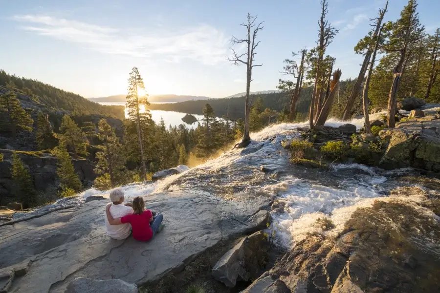 Couple sitting at the top of Eagle Falls looking at sunrise