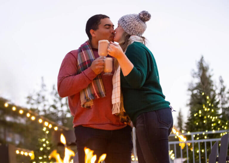 couple kissing by firepit