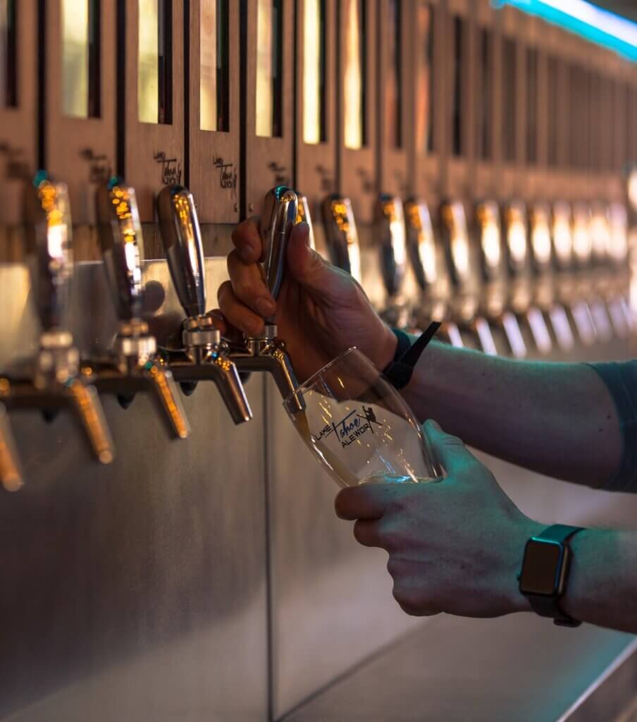 a person pouring a beer at a lake tahoe brewery