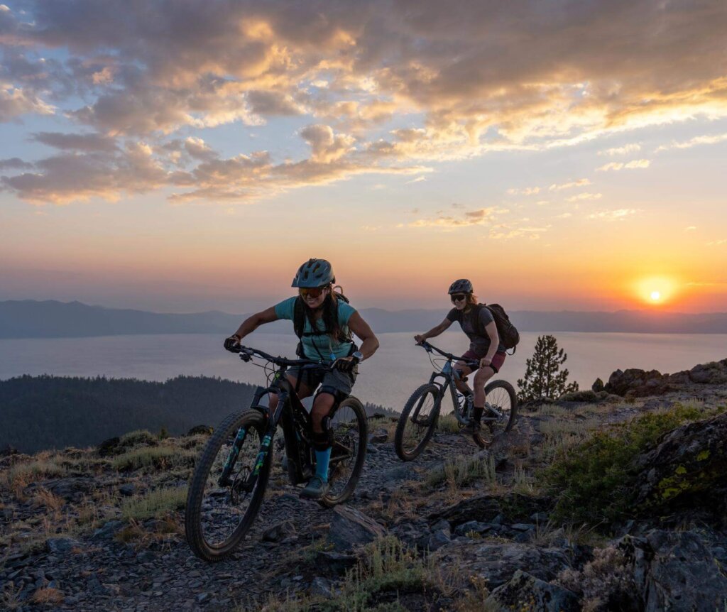 two people mountain biking at lake tahoe at sunset