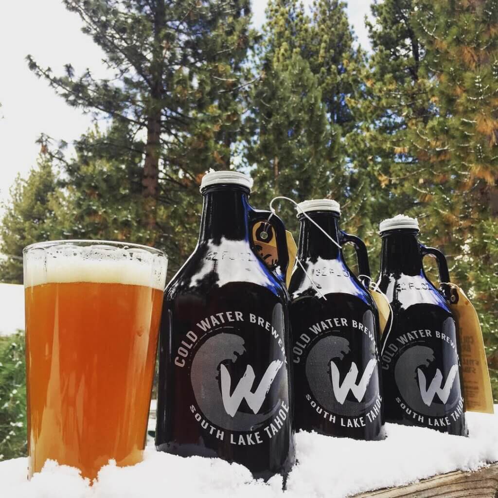 Growlers of house-brewed beer from Coldwater Brewery nestled in the snow.