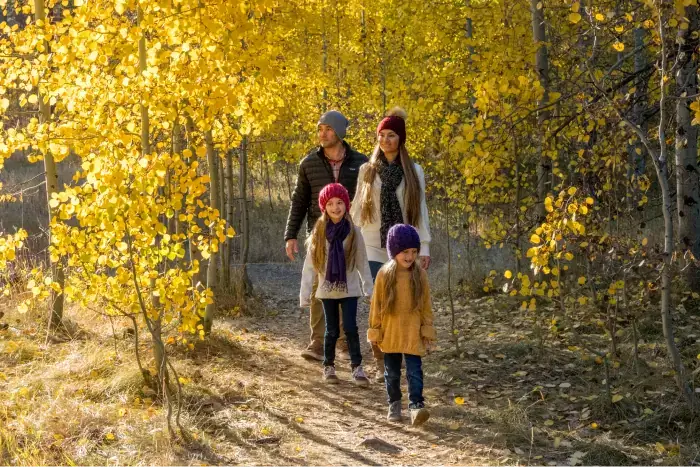 Family hiking through the multicolor fall leaves in Lake Tahoe