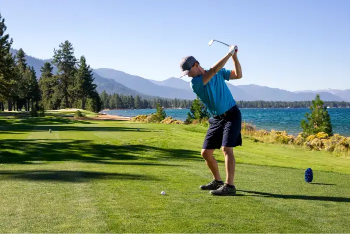 Man playing an iron shot from the tee while golfing in Lake Tahoe