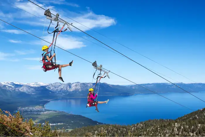 Couple enjoying the breathtaking views above the trees while ziplining in Lake Tahoe