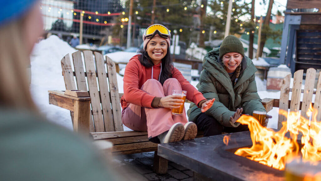friends enjoying drinks by firepit at south lake tahoe bar