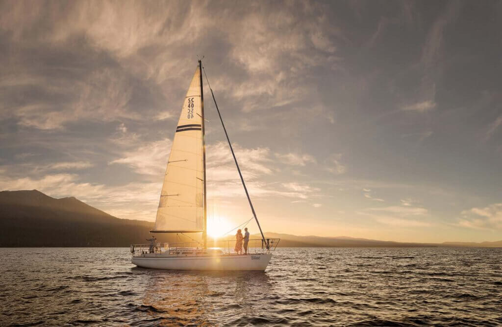 couple boating lake tahoe at sunset