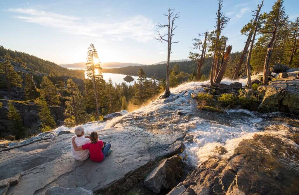 couple watching sunset at emerald bay waterfall